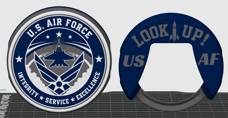 May include: A circular U.S. Air Force emblem featuring a central aircraft silhouette, stars, and the text Integrity, Service, Excellence. Beside it is a dark blue, C-shaped object with the text LOOK UP! and US AF, featuring a rocket icon.