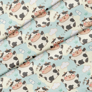 May include: A light blue fabric featuring a repeating pattern of cartoon cows with black spots, pink cheeks, and open mouths. The design includes small white clouds, green grass tufts, and white milk bottles with the text Milk printed on them.