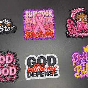 May include: Six embroidered patches featuring various designs: a Rock Star patch with a guitar, a pink ribbon Survivor patch, a Breast Cancer Awareness patch with a character, a God is Good patch, a God will be my defense patch, and a Baddie with a Bible patch.