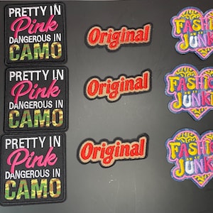 May include: Three square embroidered patches with the text 'PRETTY IN Pink DANGEROUS IN CAMO', three rectangular patches with the word 'Original' in red, and three heart-shaped patches with the text 'FASHION JUNKIE' in yellow and pink.