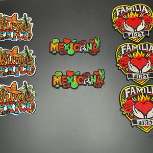 May include: A collection of eight embroidered patches. Three patches feature the text Viva Mexico with a sombrero, guitar, and cactus. Two patches display the word Mexicana with hearts and cacti. Three heart-shaped patches show hands holding a flaming heart with roses and the text Familia First.