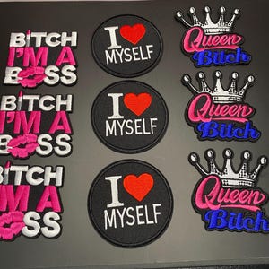 以下が含まれることがあります： 白とピンクの文字でBITCH I'M A BOSSと書かれた長方形の刺繍ワッペン3枚、赤いハートと白い文字でI LOVE MYSELFと書かれた黒い円形のワッペン3枚、ピンクと青の文字でQueen Bitchと書かれた王冠型のワッペン3枚。