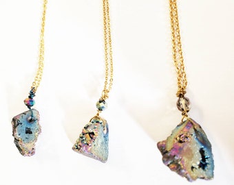 May include: Three gold chain necklaces with iridescent crystal pendants. Each pendant is a different shape and size, with a small crystal bead above the pendant.