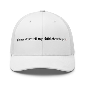 May include: A white trucker hat featuring a mesh back and a solid front panel. The text "please don't tell my child about blippi." is embroidered in black lowercase letters across the center front, with a small red dot at the end of the sentence.