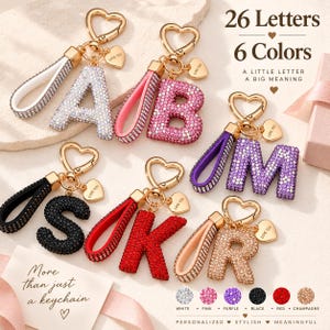 May include: A collection of six letter keychains featuring rhinestone-encrusted letters A, B, M, S, K, and R. Each keychain includes a heart-shaped clasp, a matching rhinestone-studded loop, and a small heart charm engraved with the text LOVE YOU.