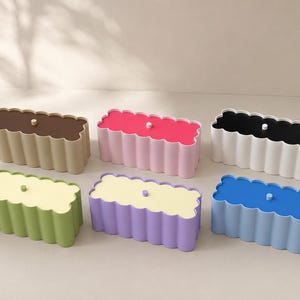 May include: Six rectangular storage boxes with scalloped edges and a single central knob on each lid. The boxes feature two-tone color combinations including brown and beige, hot pink and light pink, black and white, green and light green, purple and light yellow, and blue and light blue.