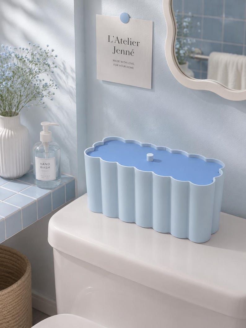 May include: A rectangular storage box with a scalloped edge design in light blue. The box features a matching light blue lid with a small central knob. The sides of the container have a vertical, fluted texture, creating a consistent, repeating pattern around the entire exterior of the storage unit.
