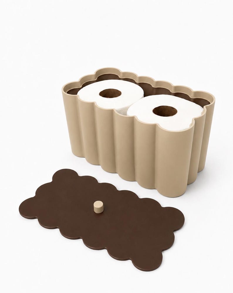 May include: A beige, scalloped-edge rectangular storage container holding two white toilet paper rolls. The container features a matching dark brown, scalloped-edge lid with a small, centered cylindrical knob for easy removal and access.
