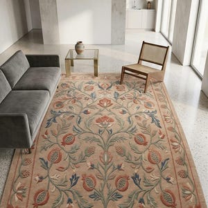 Könnte beinhalten: Ein rechteckiger Teppich mit einem symmetrischen botanischen Muster aus stilisierten Granatäpfeln, Blättern und Blumenmotiven in gedeckten Terrakotta-, Salbeigrün- und Schieferblautönen auf hellbeigem Grund mit einer dekorativen Bordüre.