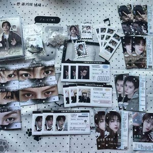 May include: A collection of K-pop merchandise including a cassette case, identity cards, photo strips, and individual portrait cards featuring various individuals. The items are decorated with star motifs and text labels like Cortis, James, and Juhoon.