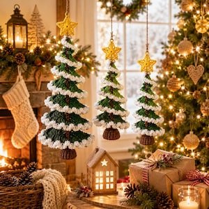 May include: Three hanging crochet Christmas tree ornaments in varying sizes, featuring dark green yarn bodies with white yarn trim spiraling around each tree. Each tree is topped with a yellow crochet star and has a brown crochet base.