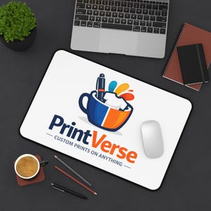 Può includere: Un tappetino da scrivania rettangolare bianco con il logo PrintVerse, che include una grafica di una tazza blu e arancione con un'icona di una penna e una maglietta, accompagnato dal testo PrintVerse CUSTOM PRINTS ON ANYTHING in lettere blu e arancioni.