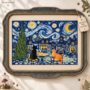 Puede incluir: Un bordado de punto de cruz que representa una noche estrellada con un alto ciprés verde, edificios azules y una luna creciente amarilla. Dos gatos, uno negro y otro naranja, están sentados a una mesa. Una etiqueta dice DIGITAL PDF PATTERN.