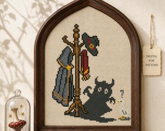 May include: A cross-stitch pattern in a dark wood arched frame featuring a coat rack with a grey cloak, a hat, and a red scarf. Beside it, a dark creature casts a shadow next to a small white bird with a question mark above its head.