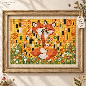 Könnte beinhalten: Ein Kreuzstich-Stickmuster mit zwei sich umarmenden Füchsen in Orange-, Gelb- und Weißtönen. Das Design enthält florale Akzente und geometrische Muster, gerahmt in einem rustikalen Goldrahmen mit einem Etikett DIGITAL PDF PATTERN.