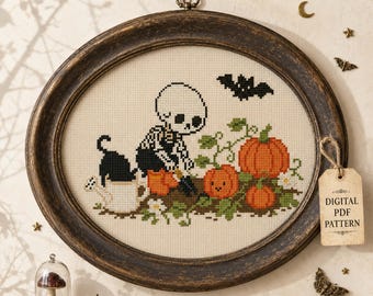 May include: An oval cross-stitch embroidery in a dark wood frame featuring a skeleton, a black cat, a white watering can, orange pumpkins, and a black bat. A beige tag attached to the frame reads Digital PDF Pattern in black text.
