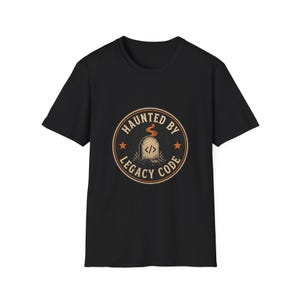 Könnte beinhalten: Ein schwarzes Kurzarm-T-Shirt mit einer kreisförmigen Grafik auf der Brust. Das Design zeigt einen Grabstein mit einem Code-Symbol, orangefarbenem Rauch und dem Text "HAUNTED BY LEGACY CODE" in einem orangefarbenen Kreis mit zwei Sternen.