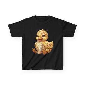 May include: A black short-sleeve t-shirt featuring a central graphic of a fluffy yellow duckling sitting down and holding a small clear bottle of bubble tea with Japanese text printed on the label. The duckling has large eyes and orange feet.