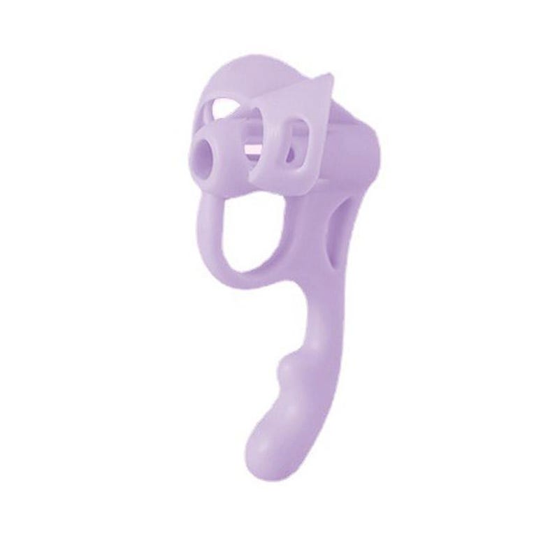 May include: A light lavender ergonomic writing aid featuring a contoured grip with a central circular opening and a curved handle. The device is constructed from a smooth, solid material with a uniform matte finish and a distinct, asymmetrical shape.