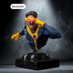 Może przedstawiać: Popiersie Cyklopa, postaci z X-Men, w niebiesko-żółtym kostiumie z czerwonym emblematem X. Figurka ma zdecydowany wyraz twarzy, nosi wizjer z czerwoną soczewką. Zamontowany na czarnej podstawie imitującej marmur. Słowo "Bestseller" znajduje się w lewym górnym rogu.