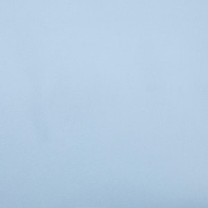 May include: A solid, uniform field of light baby blue color. The surface appears smooth and matte, displaying a consistent, flat tone across the entire frame without any visible patterns, textures, gradients, or additional objects present.