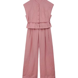May include: A dusty pink sleeveless jumpsuit featuring a mandarin collar, a button-down front closure, two chest pockets, and a thin matching waist tie. The garment has wide-leg trousers with a pleated front design and a clean, solid-colored finish.