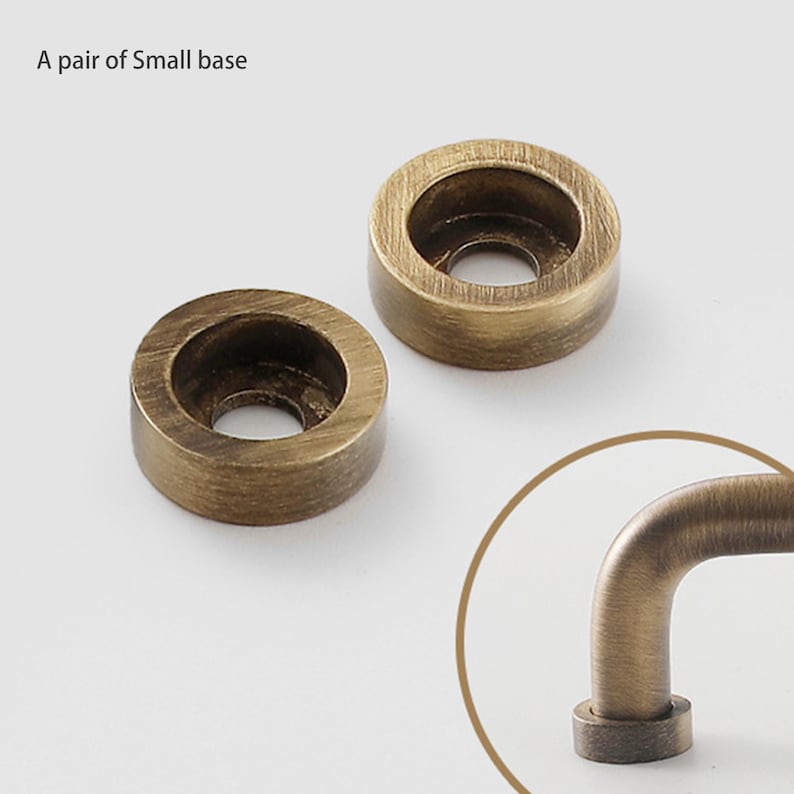 May include: A pair of small circular bases with a brushed antique brass finish, each featuring a central hole. The text A pair of Small base is visible in the upper left corner, and a partial view of a curved handle is shown in a circle.