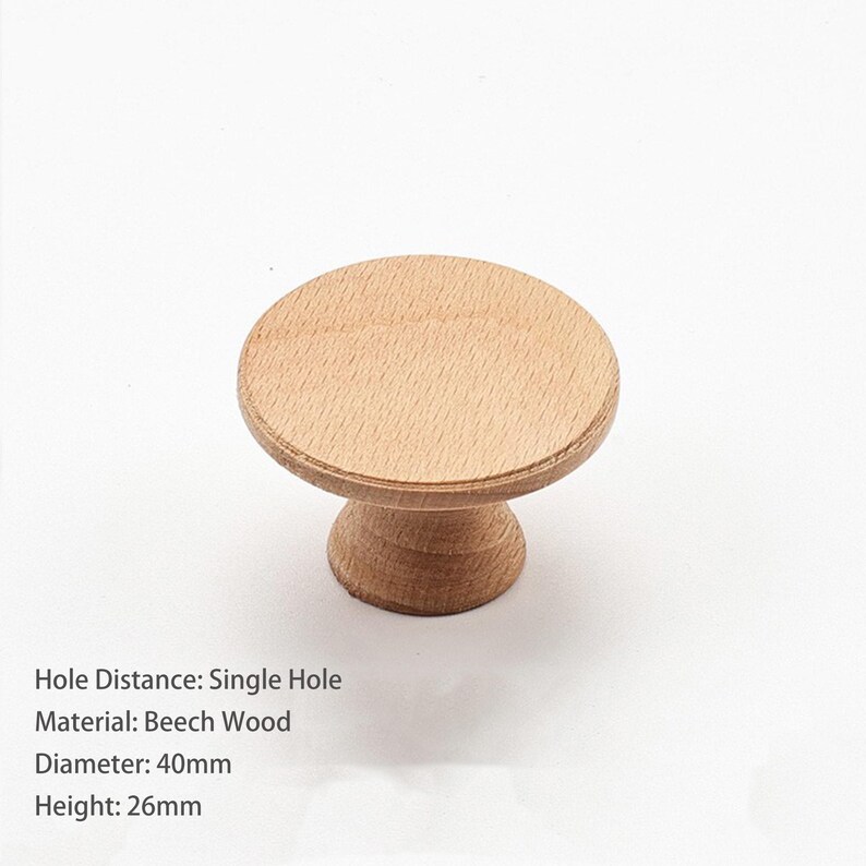 May include: A round light brown beech wood cabinet knob with a flat circular top and a tapered base. The knob features a single hole mounting design, a diameter of 40mm, and a height of 26mm. The wood grain is visible across the surface.