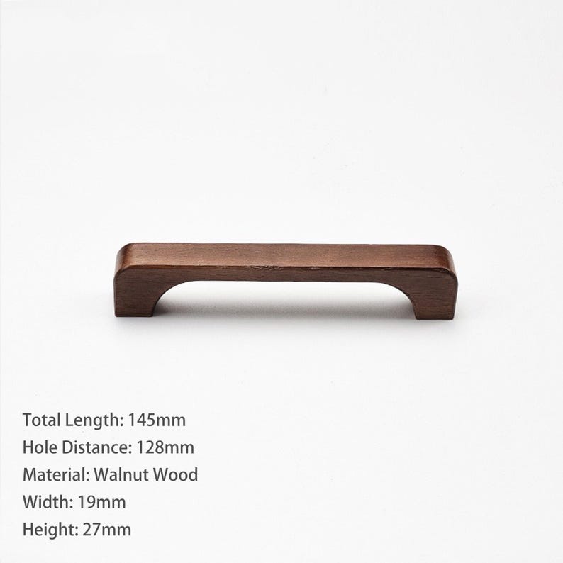 May include: A dark brown walnut wood cabinet handle with a curved underside. The handle has a total length of 145mm, a hole distance of 128mm, a width of 19mm, and a height of 27mm. The text on the image specifies these exact dimensions.