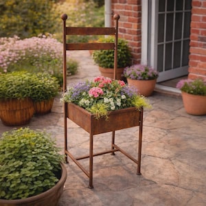 May include: A rustic metal chair planter filled with colorful flowers, set on a stone patio. The chair has a rectangular planter box and a decorative top. Other potted plants and flowers are in the background.