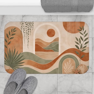 May include: A rectangular bath mat featuring a printed landscape design with terracotta, sage green, and cream tones. The graphic includes arched doorways, rolling hills, a sun, hanging vines, a palm leaf, a seashell, and a starfish.