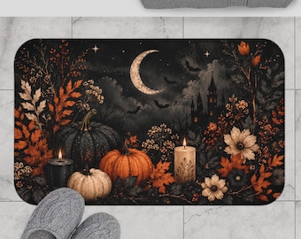 Könnte beinhalten: Eine rechteckige Badematte mit einer dunklen, atmosphärischen Szene, die eine Mondsichel, die Silhouette eines Schlosses, fliegende Fledermäuse und herbstliches Laub zeigt. Das Design umfasst drei Kürbisse in Orange- und Grautönen sowie zwei Kerzen.