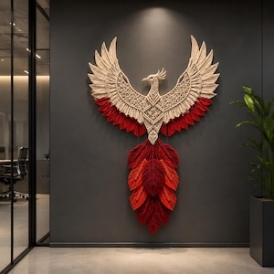 May include: A large wall hanging crafted from macrame cord in the shape of a phoenix. The upper body and wings feature intricate cream-colored knots, while the wing tips and the long, layered tail feathers are dyed in vibrant shades of red.