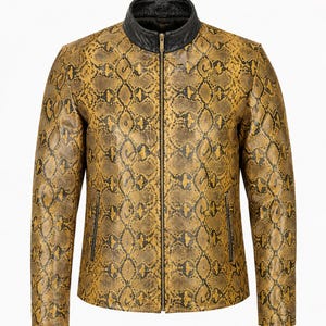 Peut inclure: Une veste à manches longues avec un motif peau de serpent jaune et noir. Le vêtement comprend un col montant noir, une fermeture éclair verticale centrale et deux poches latérales zippées. La texture semble être en cuir.