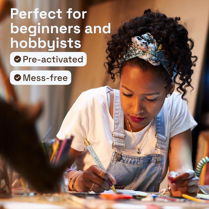 May include: A white and gold metallic marker pen with the text ARTIST printed on the barrel. The marker features a fine tip and is held in a hand while being used on a surface. The text on the image reads: Perfect for beginners and hobbyists, Pre-activated, Mess-free.