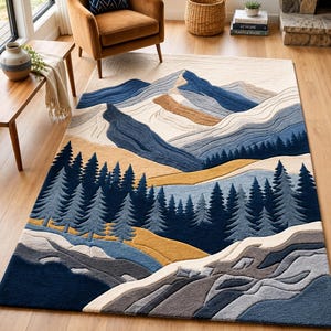 Op de afbeelding: Een rechthoekig vloerkleed met een landschapsontwerp met gelaagde bergen in tinten blauw, crème en beige. De voorgrond toont een dicht bos van donkerblauwe dennenbomen boven een getextureerd, rotsachtig terrein in grijze en blauwe tinten.