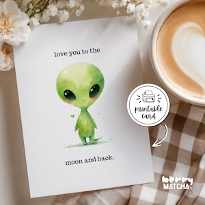 May include: A white greeting card featuring a watercolor illustration of a small green alien with large black eyes. The text reads love you to the moon and back. A circular sticker on the card displays a printer icon and the text printable card.