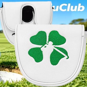 Op de afbeelding: Een witte mallet putter headcover met een geborduurd groen klavertjevier-ontwerp waarin een golfclub-afbeelding in het midden is verwerkt. De hoes heeft een gestructureerde, ronde vorm met witte biezen langs de randen en een zwarte binnenkant.