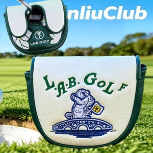 May include: A white and dark green golf putter headcover featuring the embroidered text L.A.B. GOLF and a graphic of a character holding a flag on a bridge. The design includes a smaller matching headcover view and the text nliuClub in the corner.
