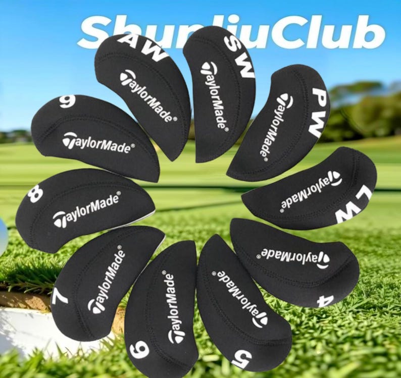 Op de afbeelding: Een set zwarte TaylorMade golfijzer-headcovers gerangschikt in een cirkelvormig patroon. Elke cover bevat witte tekst die het clubnummer of type aangeeft, waaronder 4, 5, 6, 7, 8, 9, PW, AW, SW en LW, samen met het TaylorMade-logo.