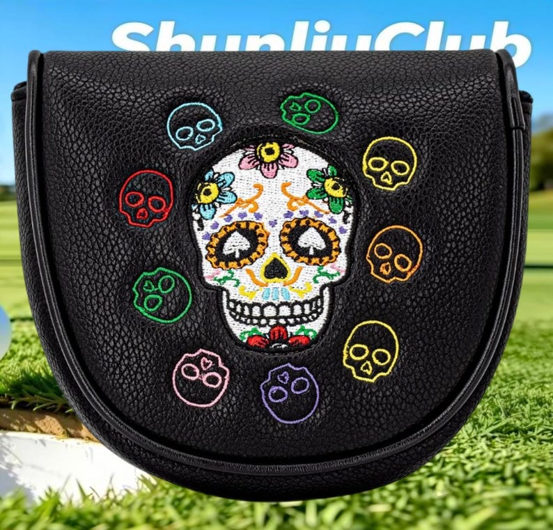 May include: A black textured mallet putter headcover featuring a central embroidered sugar skull with colorful floral details and spade-shaped eyes, surrounded by eight smaller embroidered skulls in various colors. The text ShunliuClub is visible.