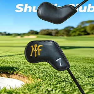 May include: Two black leather golf club head covers with stitched edges. The lower cover features a gold embroidered monogram logo and a white embroidered number 7. The text "Shuttle Club" is visible in the upper portion of the image.