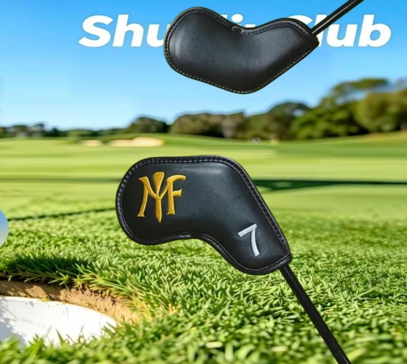 May include: Two black leather golf club head covers with stitched edges. The lower cover features a gold embroidered monogram logo and a white embroidered number 7. The text "Shuttle Club" is visible in the upper portion of the image.