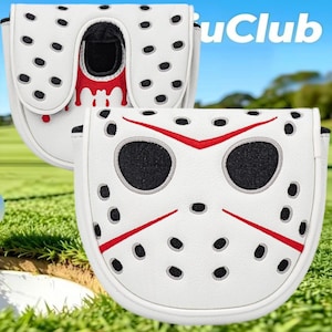 Op de afbeelding: Twee witte mallet putter covers met een ijshockeymaskerontwerp met zwarte cirkelvormige gaten, rode accenten en zwarte oogopeningen. De covers zijn gemaakt van wit materiaal met geborduurde details. De tekst "uClub" is rechtsboven zichtbaar.