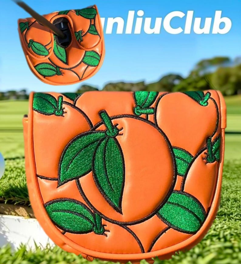 Op de afbeelding: Een oranje golfputter headcover met een geborduurd patroon van feloranje vruchten met glinsterende groene bladeren. Het ontwerp toont een bovenaanzicht met de opening voor de schacht en een vooraanzicht van het gedetailleerde fruitmotief.