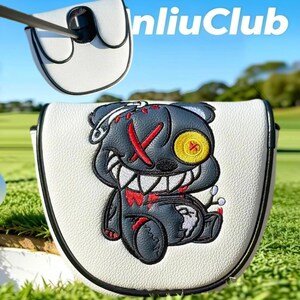 May include: A white mallet putter headcover with black trim featuring an embroidered dark gray bear character with a yellow button eye, red stitched X eye, and sharp white teeth. The text "nliuClub" is visible in the upper right corner.