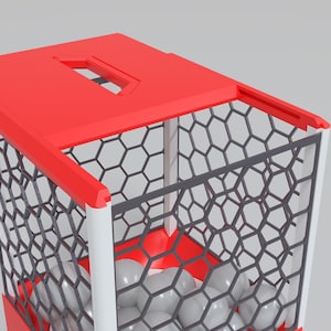 May include: A red and white geometric container with a hexagonal pattern and a red top. The container holds several gray spheres. The design is modern and minimalist.