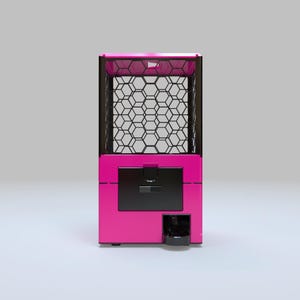 May include: A pink and black claw machine with a hexagonal grid pattern. The machine has a black door and a coin slot. The top of the machine is also black.