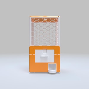 May include: An orange and white gumball machine with a honeycomb pattern on the front. The machine has a white dispensing area and a small, white cup-like receptacle at the bottom. The top of the machine is also orange.