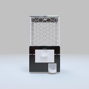 May include: A modern gumball machine with a black base and white accents. The top section features a hexagonal grid design, and a white dispensing area is located in the center. A small, white cup sits below.